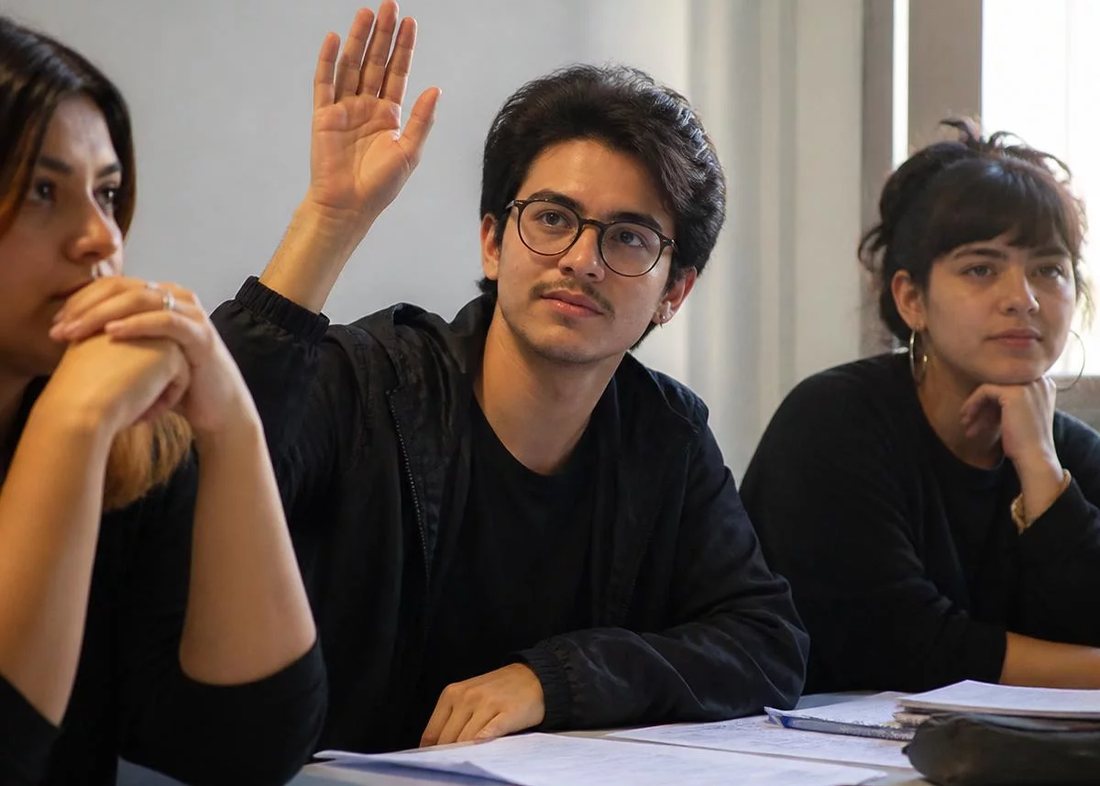 Dupla preparando a rodada seguinte, com caderno aberto e canetas coloridas na mesa